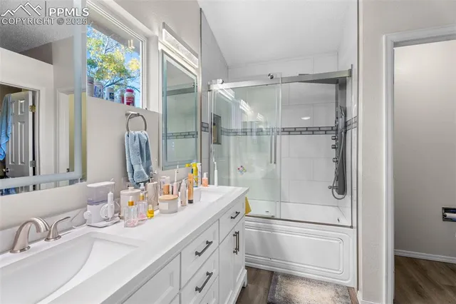 a bathroom with a granite countertop sink mirror and a shower