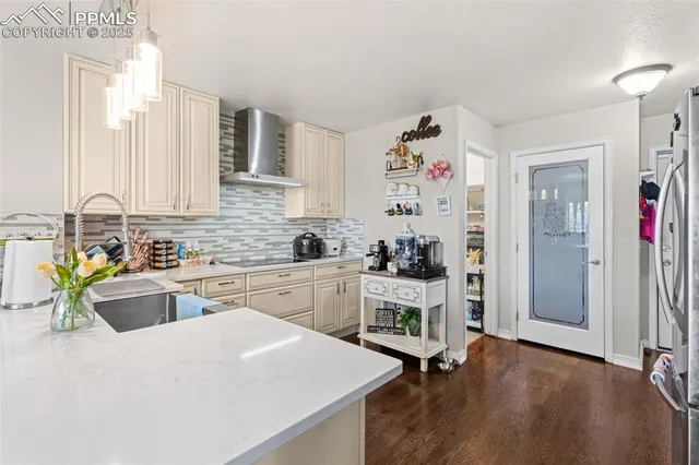 a kitchen that has a lot of cabinets in it and wooden floor