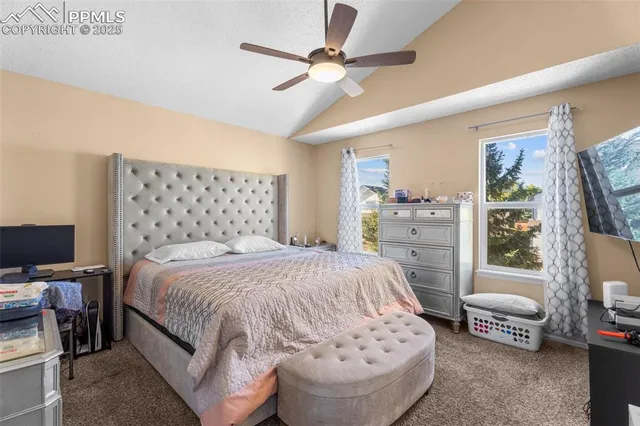 a bedroom with a bed a couch and a flat tv screen