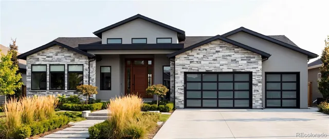 front view of a house with a large window and potted plants