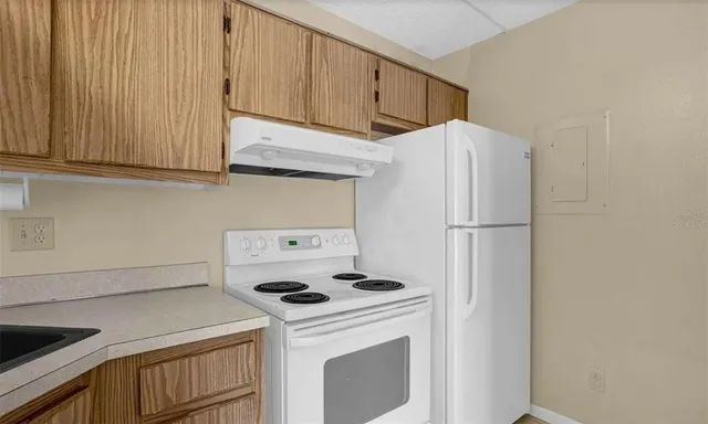 a kitchen with a refrigerator sink stove and cabinets