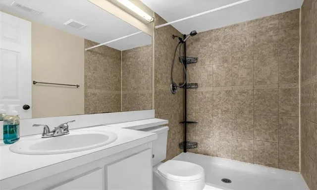 a bathroom with a sink a toilet and shower