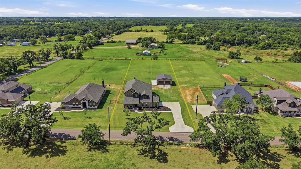 864 Shadow Valley Road Whitesboro, TX 76273 - Photo 5 of 40 Expansive residential property featuring a large dwelling, a detached garage, and a substantial green lawn