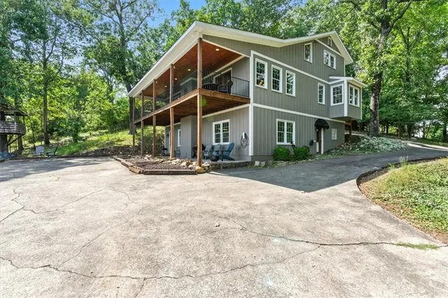 a backyard of a house with plants and large tree