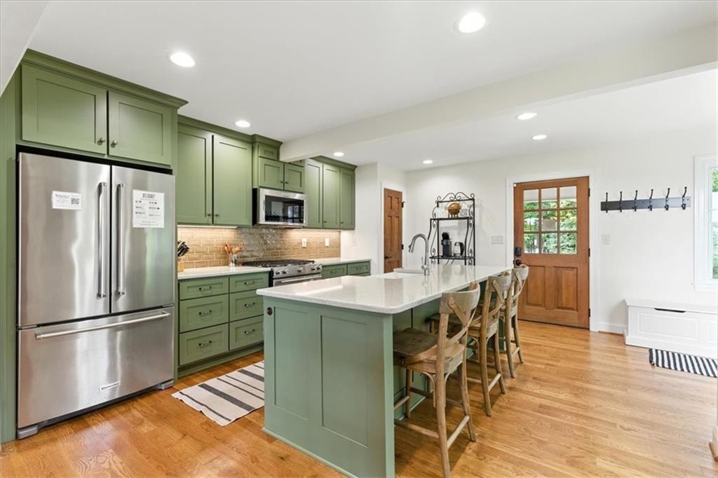 11 Brow Road Rome, GA 30165 - Photo 8 of 58 a kitchen with stainless steel appliances granite countertop a refrigerator a stove a sink a dining table and chairs with wooden floor