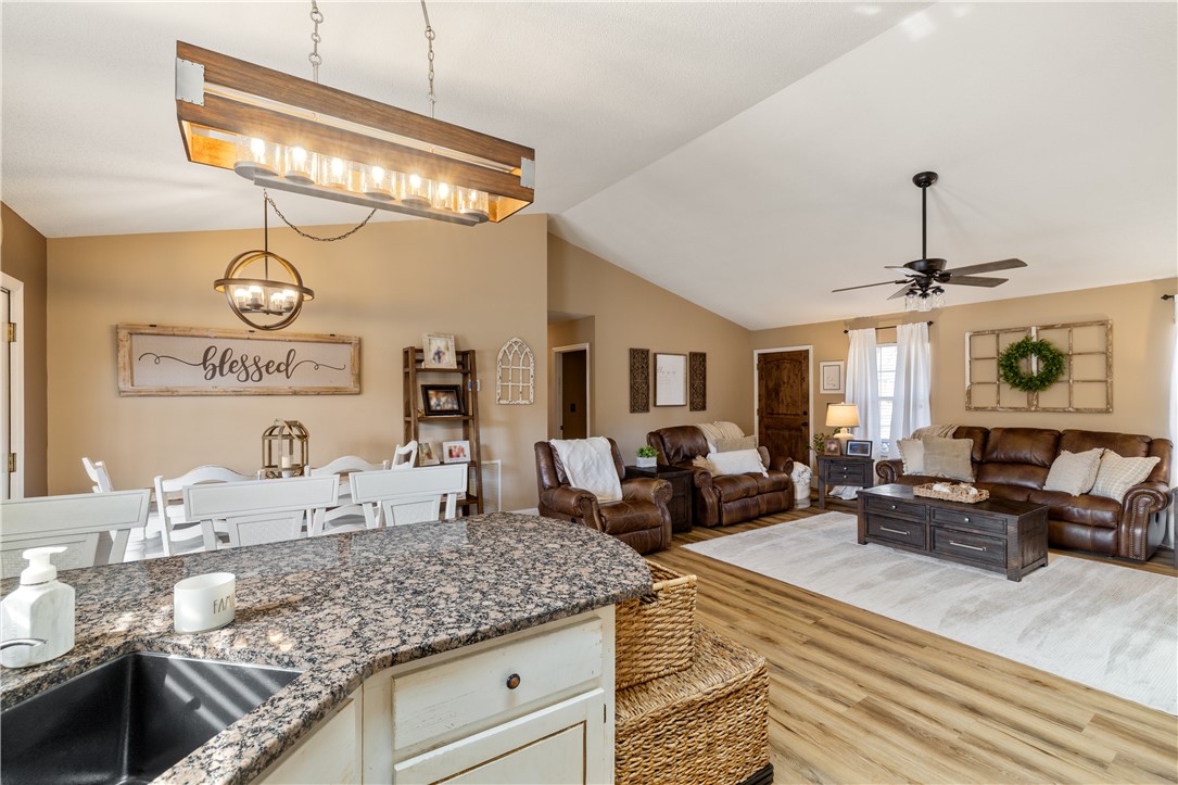 903 Huckleberry Lane Anderson, SC 29625 - Photo 12 of 42 An inviting open-concept area blends dining and living spaces under vaulted ceilings and warm lighting.