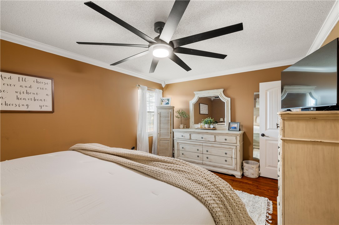 903 Huckleberry Lane Anderson, SC 29625 - Photo 25 of 42 This inviting bedroom features rich wood flooring, crown molding, and ample natural light for a tranquil retreat.