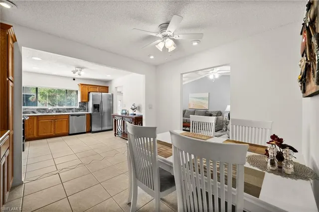 a kitchen with stainless steel appliances kitchen island granite countertop a refrigerator a stove a sink dishwasher and white cabinets with wooden floor