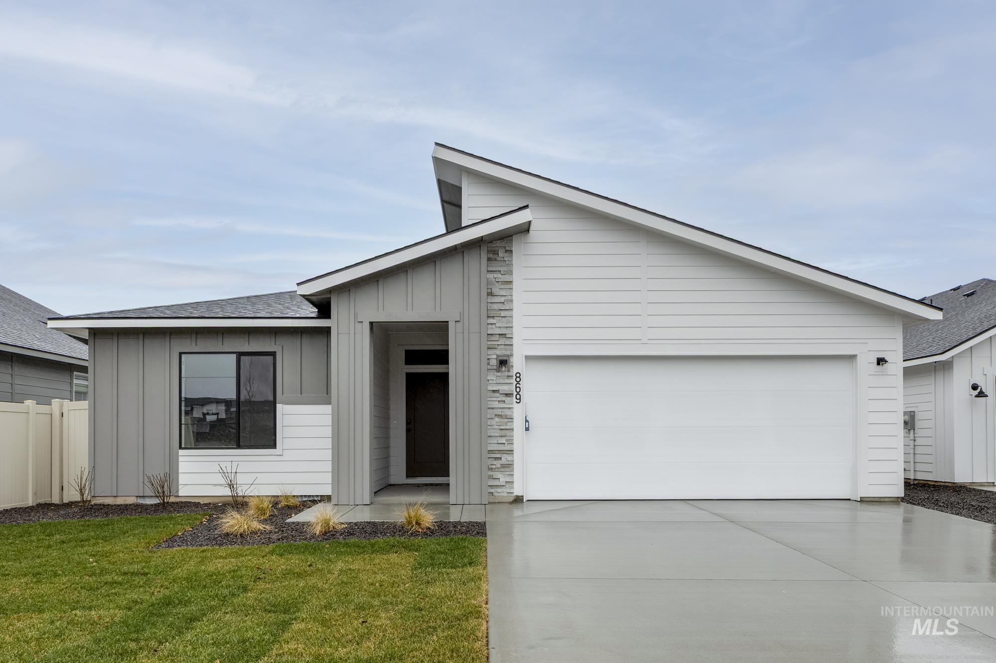 View of front of house featuring board and batten siding, concrete driveway, roof with shingles, and a garage