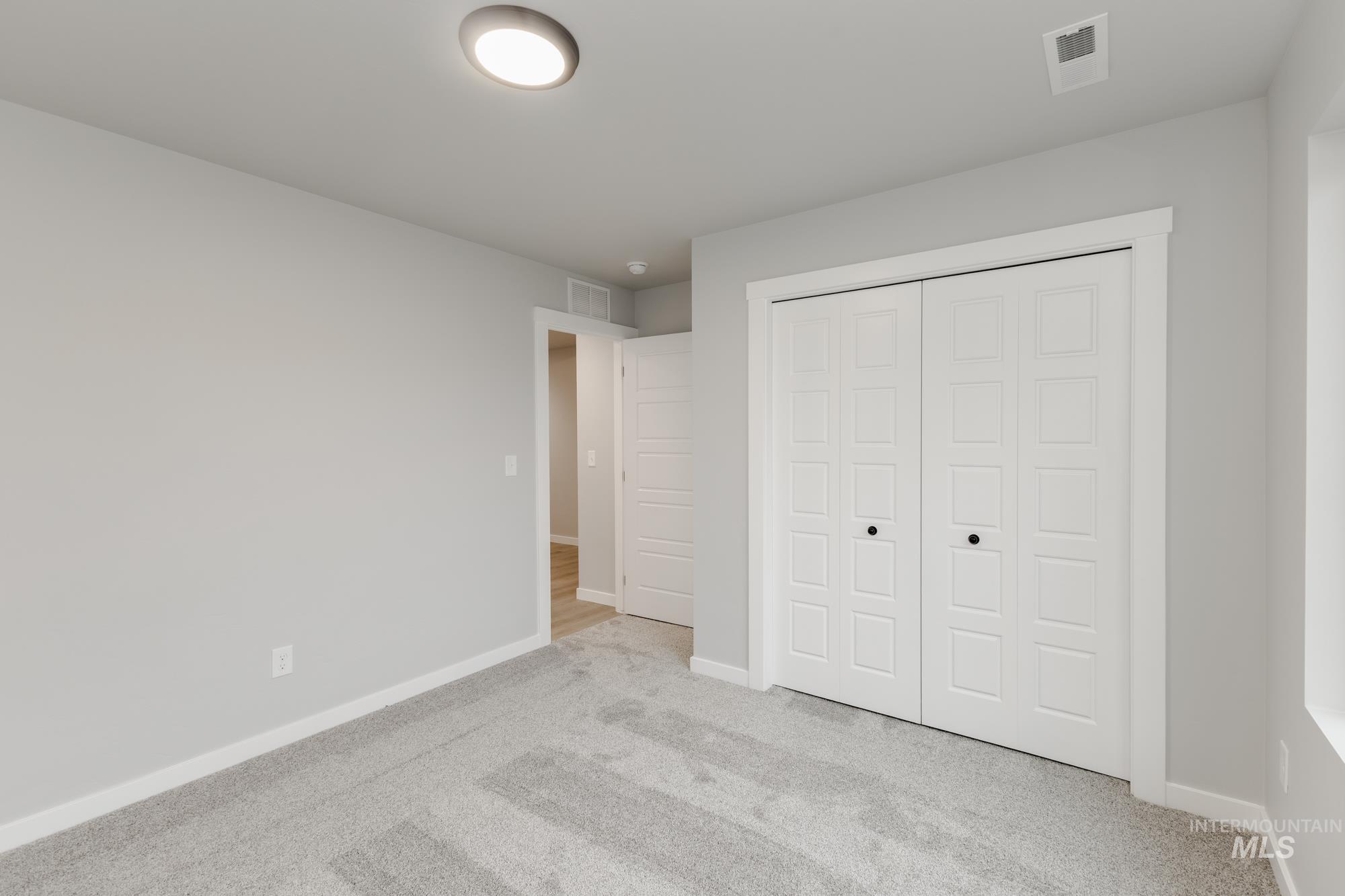 869 North Aleppo Way Meridian, ID 83642 - Photo 14 of 22 Unfurnished bedroom featuring light colored carpet and a closet