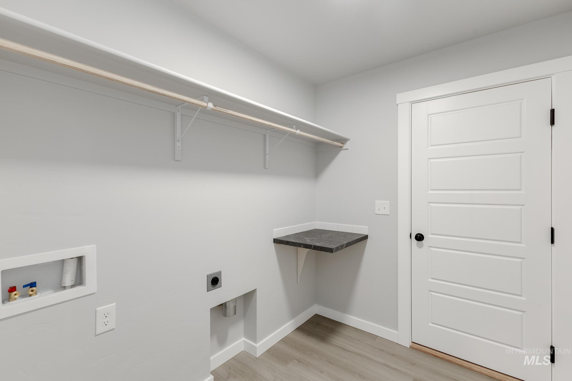 869 North Aleppo Way Meridian, ID 83642 - Photo 18 of 22 Laundry room featuring light wood-type flooring, hookup for a washing machine, and hookup for an electric dryer