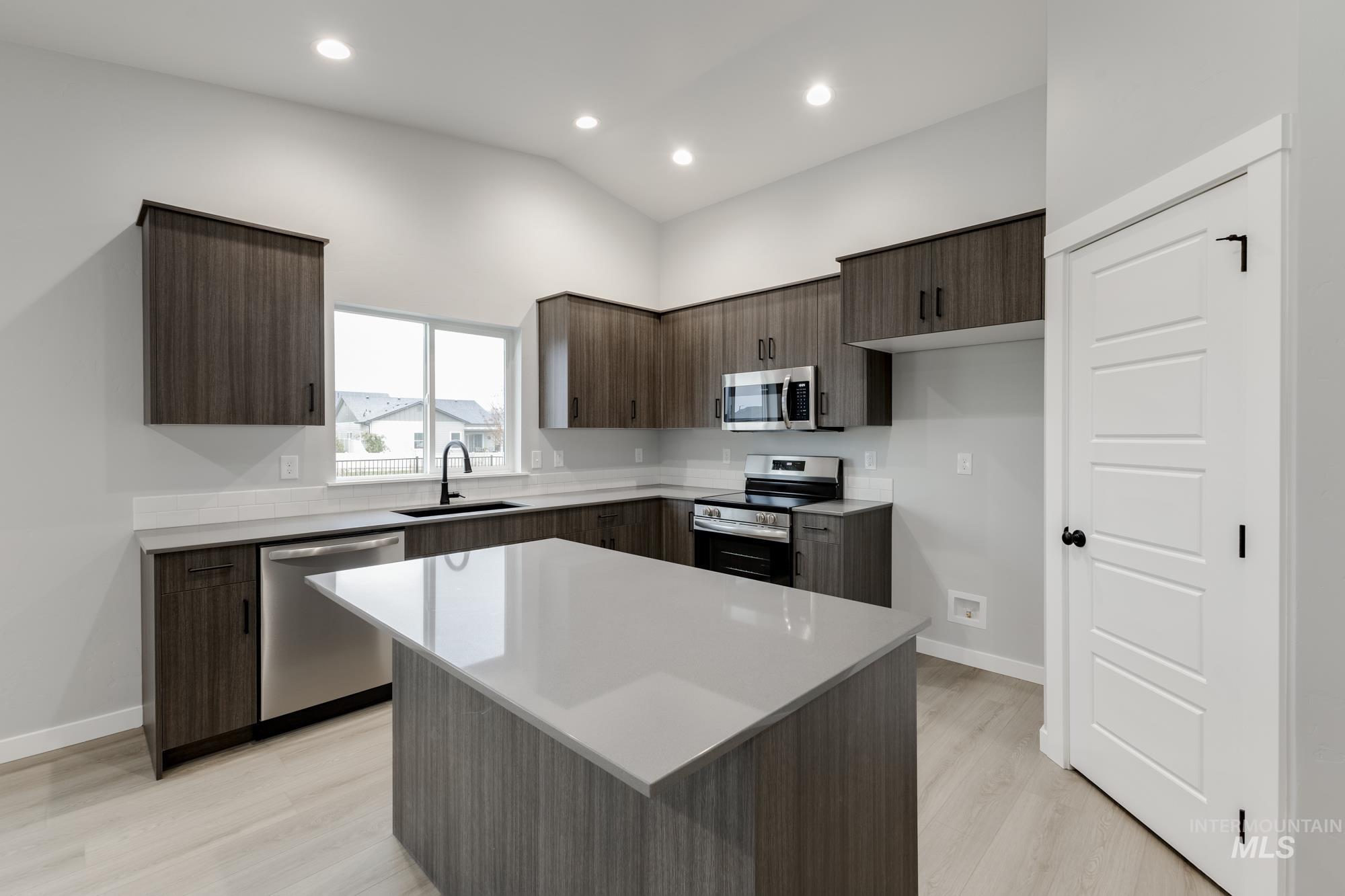 869 North Aleppo Way Meridian, ID 83642 - Photo 3 of 22 Kitchen with dark brown cabinets, modern cabinets, stainless steel appliances, light wood-type flooring, and recessed lighting