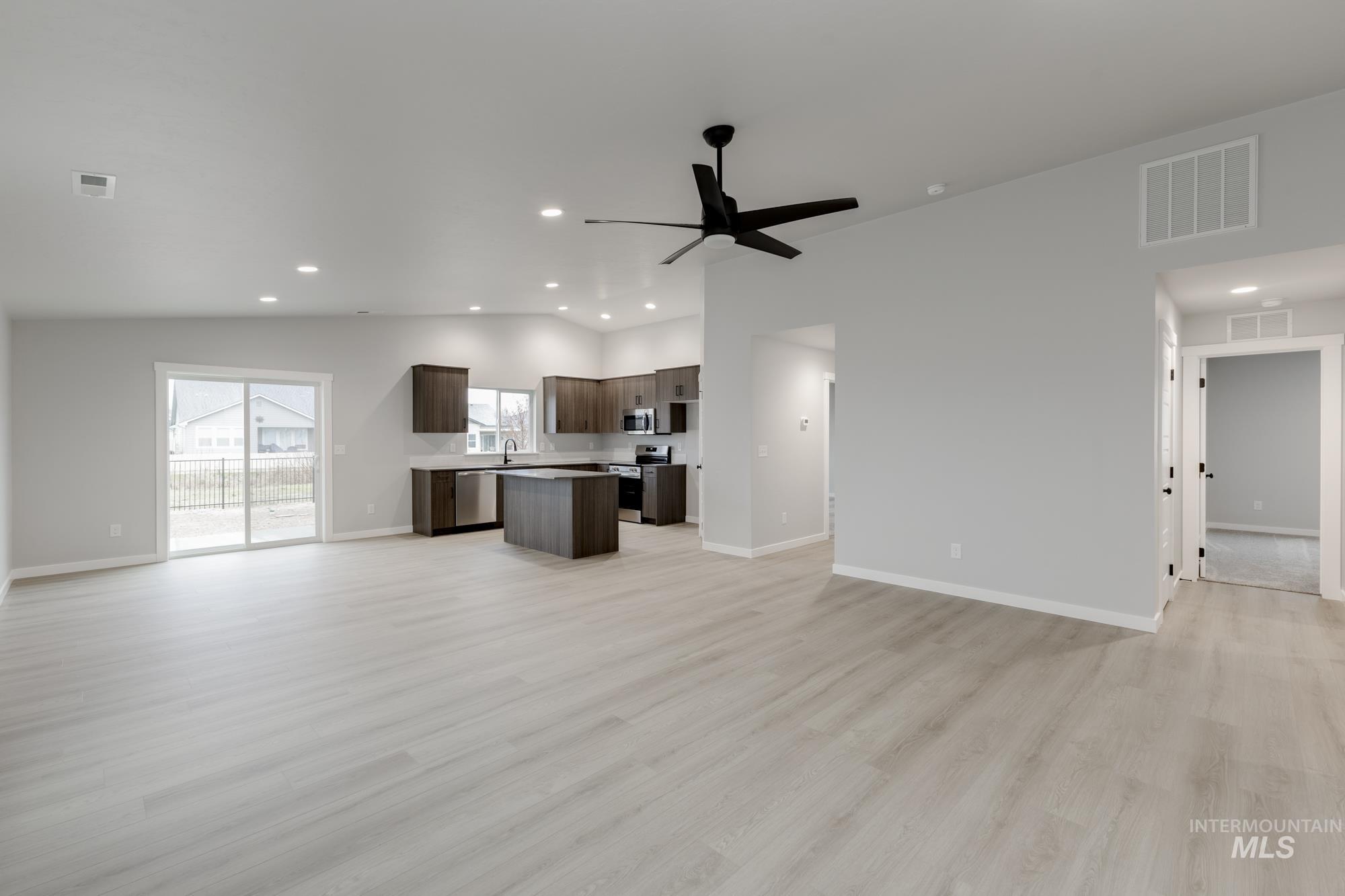 869 North Aleppo Way Meridian, ID 83642 - Photo 9 of 22 Unfurnished living room featuring light wood finished floors, recessed lighting, a ceiling fan, and vaulted ceiling