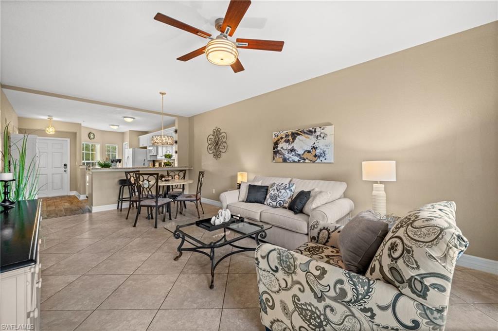9175 Celeste Drive, Unit 306 Naples, FL 34113 - Photo 11 of 24 a living room with furniture and a chandelier