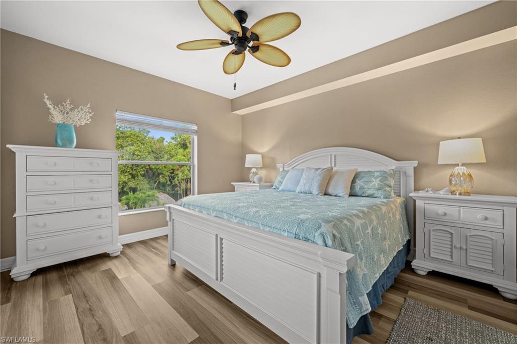 9175 Celeste Drive, Unit 306 Naples, FL 34113 - Photo 13 of 24 a bedroom with a bed a dresser and a chandelier