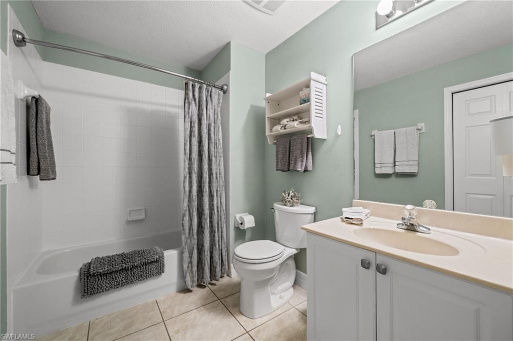 9175 Celeste Drive, Unit 306 Naples, FL 34113 - Photo 15 of 24 a bathroom with a sink a toilet a mirror and shower