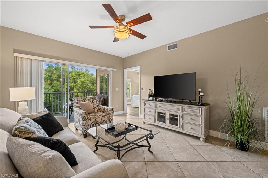 9175 Celeste Drive, Unit 306 Naples, FL 34113 - Photo 9 of 24 a living room with furniture and a flat screen tv