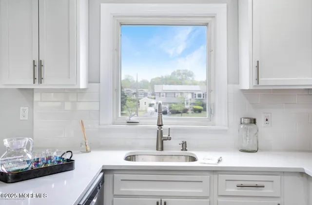 a kitchen with stainless steel appliances granite countertop a sink and a white cabinets