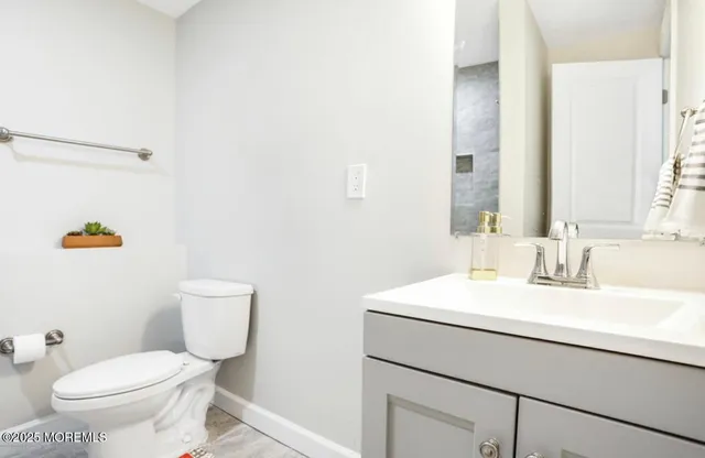 a white toilet sitting next to a bathroom sink and a shower