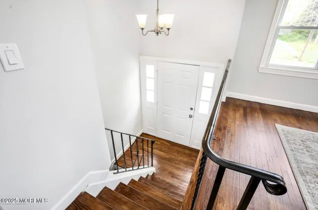 a view of entryway and hall with wooden floor