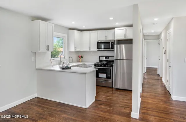 a kitchen with white cabinets and stainless steel appliances