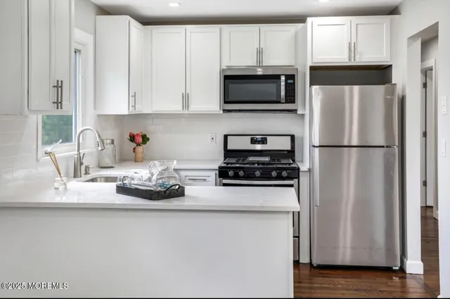 a kitchen with stainless steel appliances a refrigerator a stove a microwave and cabinets