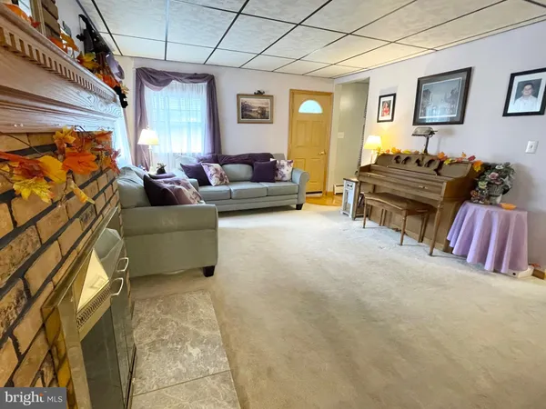 a living room with furniture a flat screen tv and a window