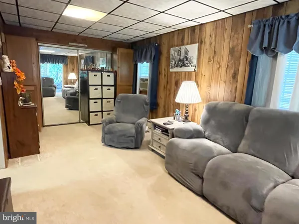 a living room with furniture a chandelier and a flat screen tv