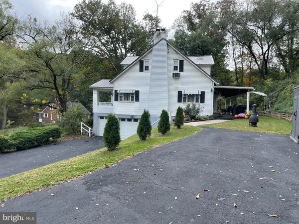 a view of a house with backyard and trees