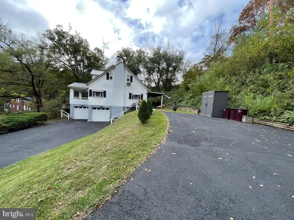 a view of a house with a yard and large tree