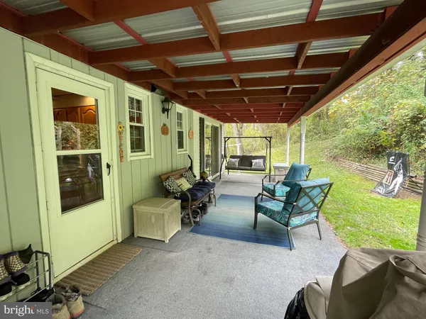 a view of a porch with furniture and a yard