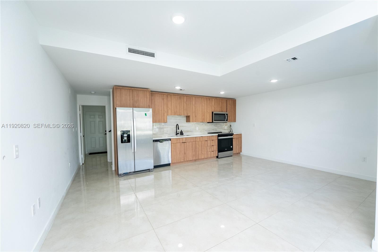 14580 Southwest 261st Street Homestead, FL 33032 - Photo 5 of 23 a large white kitchen with a refrigerator a sink and a cabinets