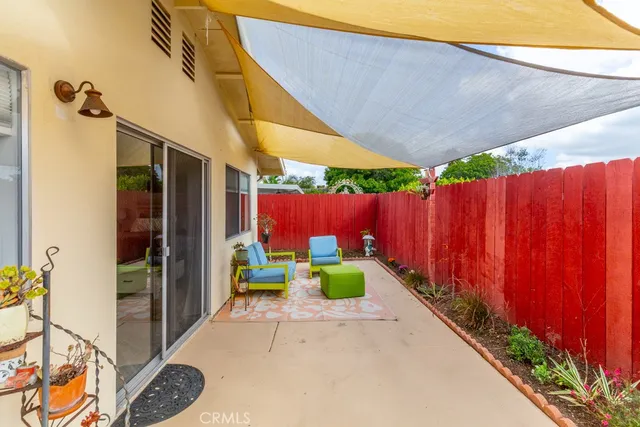 a view of a backyard with table and chairs with wooden fence