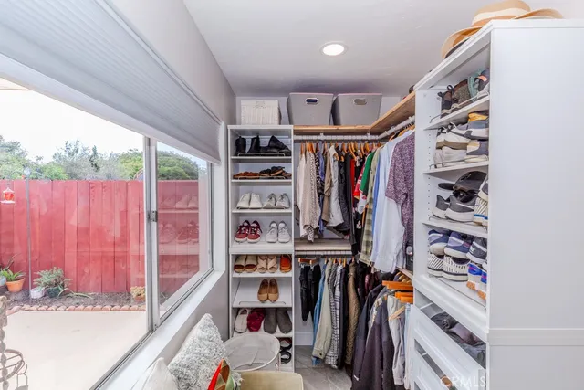a view of walk in closet with clothes and shoes