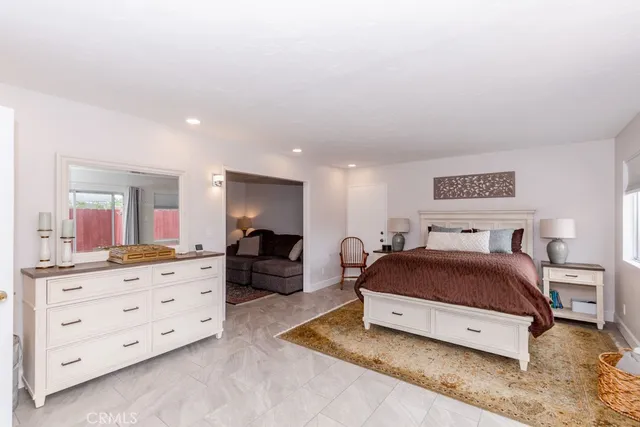 a spacious bedroom with a bed and dresser