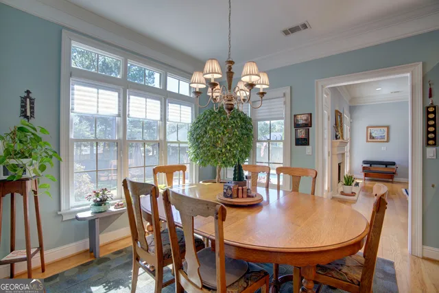 a kitchen with stainless steel appliances granite countertop a stove a sink a refrigerator a dining table and chairs