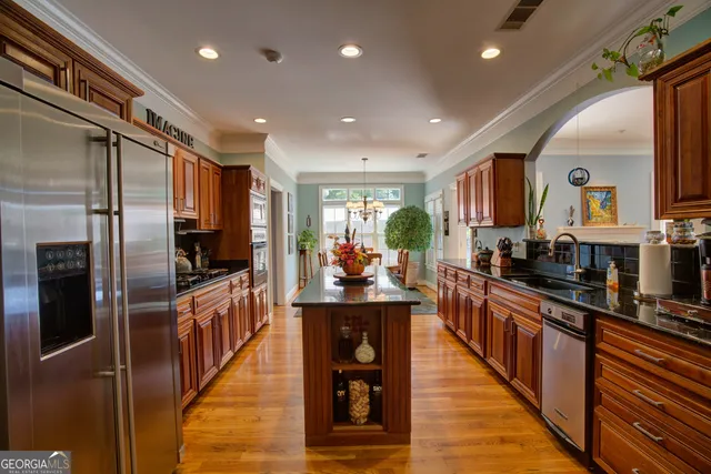a kitchen with stainless steel appliances granite countertop wooden cabinets a sink and a stove