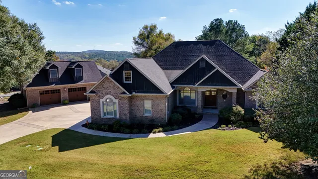 a front view of house with yard and trees in the background