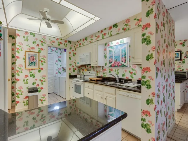 a kitchen with stainless steel appliances granite countertop a sink and a refrigerator