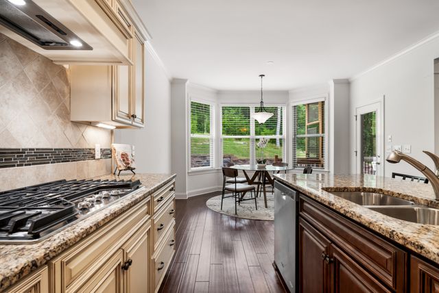 a kitchen with a stove a sink a dining table and chairs