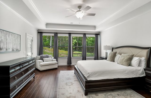 a bedroom with a bed couch and a large window with outer view