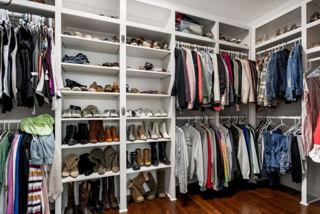 a view of walk in closet with clothes and shoes