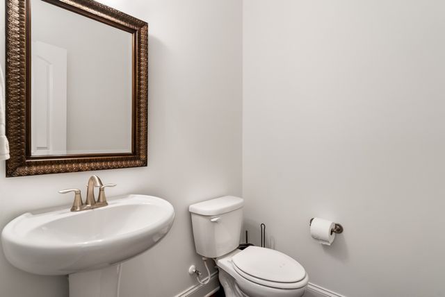 a bathroom with a sink mirror and toilet