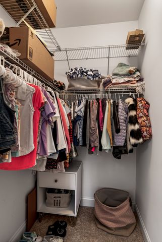 a view of walk in closet with clothes and shoes