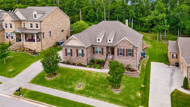 a aerial view of a house with yard and green space