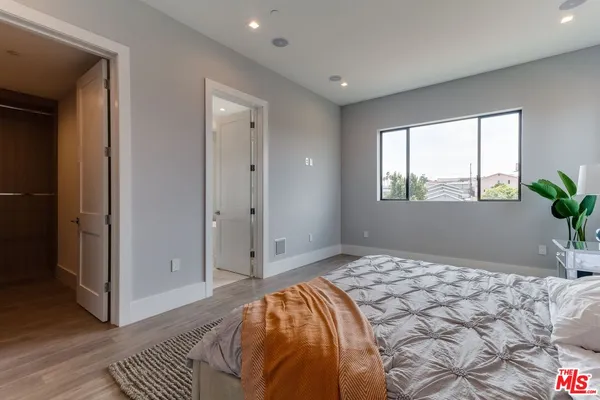 a bedroom with a bed and wooden floor