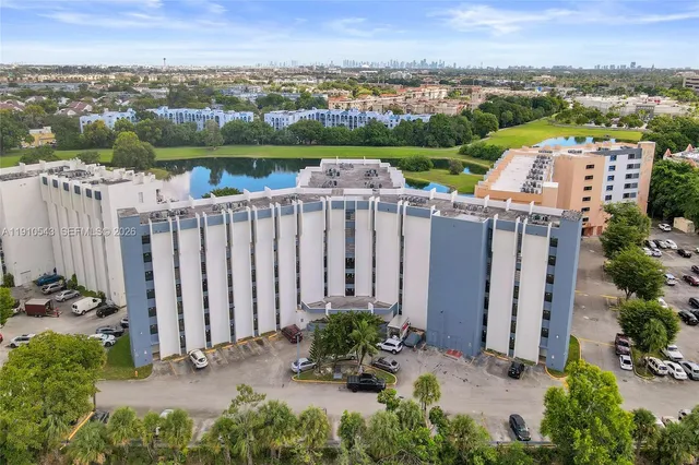 an aerial view of a house with a garden and lake view