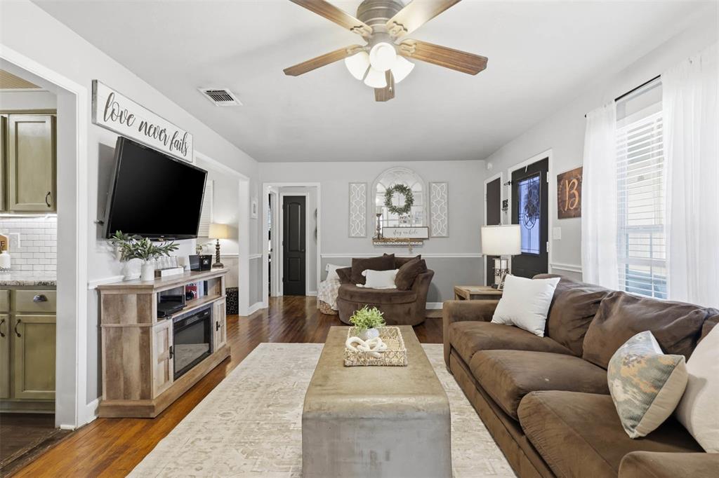 308 West 1st Street Springtown, TX 76082 - Photo 11 of 39 Living area featuring wood-finish flooring, a ceiling fan with integrated lighting, and light gray wall tones
