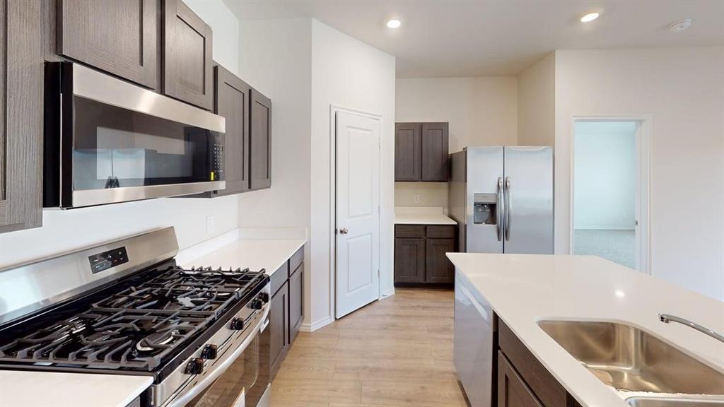 4124 Turquoise Avenue Celina, TX 75009 - Photo 4 of 17 a kitchen with a refrigerator stove and microwave