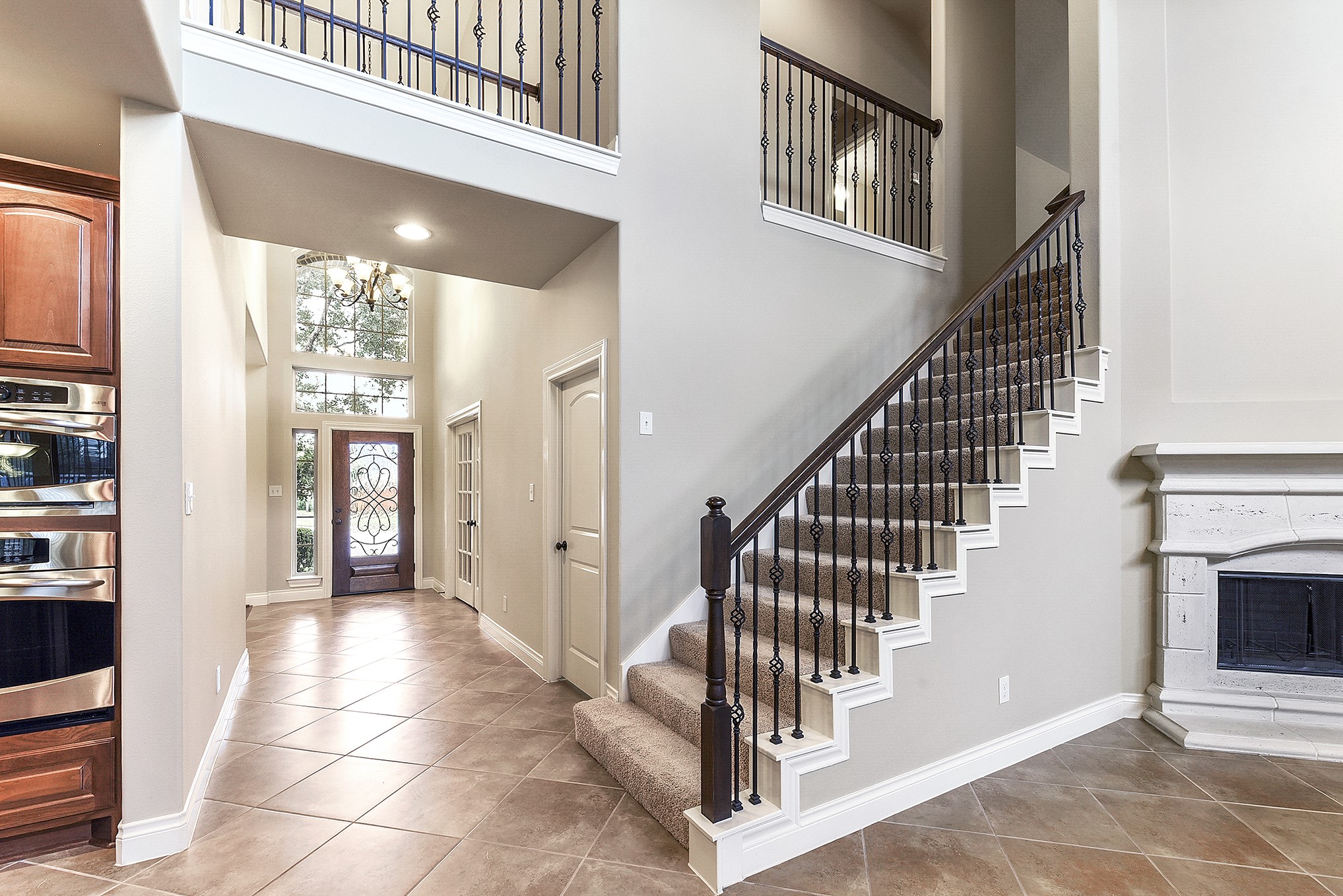 29023 Powder Ridge Drive Katy, TX 77494 - Photo 12 of 50 Another view of the grand, spacious foyer from the front door showcases the elegant staircase and beautiful sightlines into the large living room. Beyond the staircase, the living room welcomes you with a cozy gas fireplace, creating a warm and inviting gathering space.
